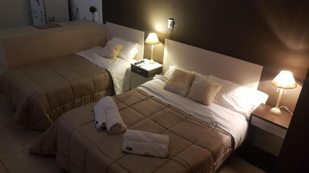 Habitación de hotel con 2 camas y 2 lámparas en Del Pilar II en La Rioja