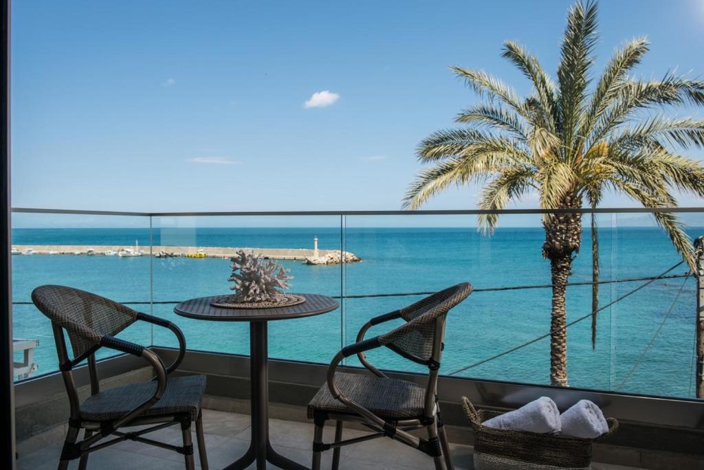 a balcony with a table and chairs and a palm tree at Sonia Center II in Hersonissos