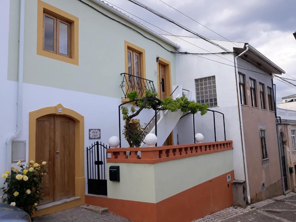 Casa blanca con balcón con plantas. en Casa d'Avó en Miranda do Corvo
