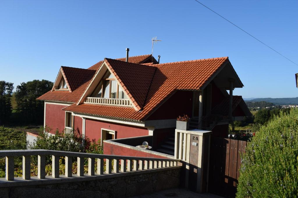 una casa con techo rojo y valla en Casa De Campo Clara, en Santa Cristina