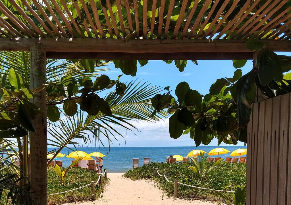 widok na plażę z parasolami i ocean w obiekcie Vila Araticum Praia w mieście Santo André