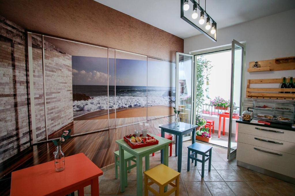 Habitación con mesa, sillas y un cuadro en la pared. en B&B Scirocco House, en Oliveri