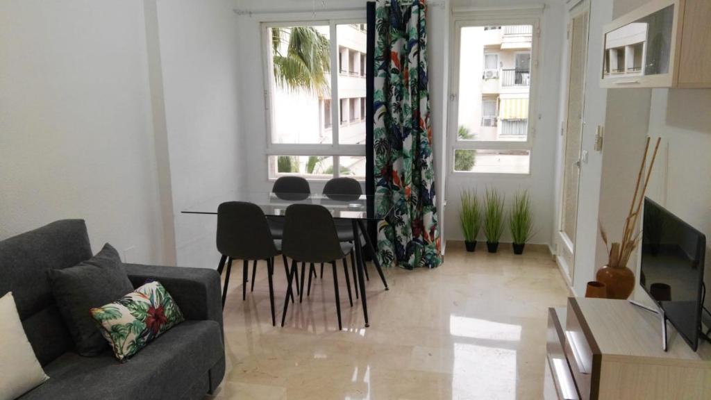 - un salon avec un canapé, une table et des chaises dans l'établissement Azul Rentals Albir flat, à Albir