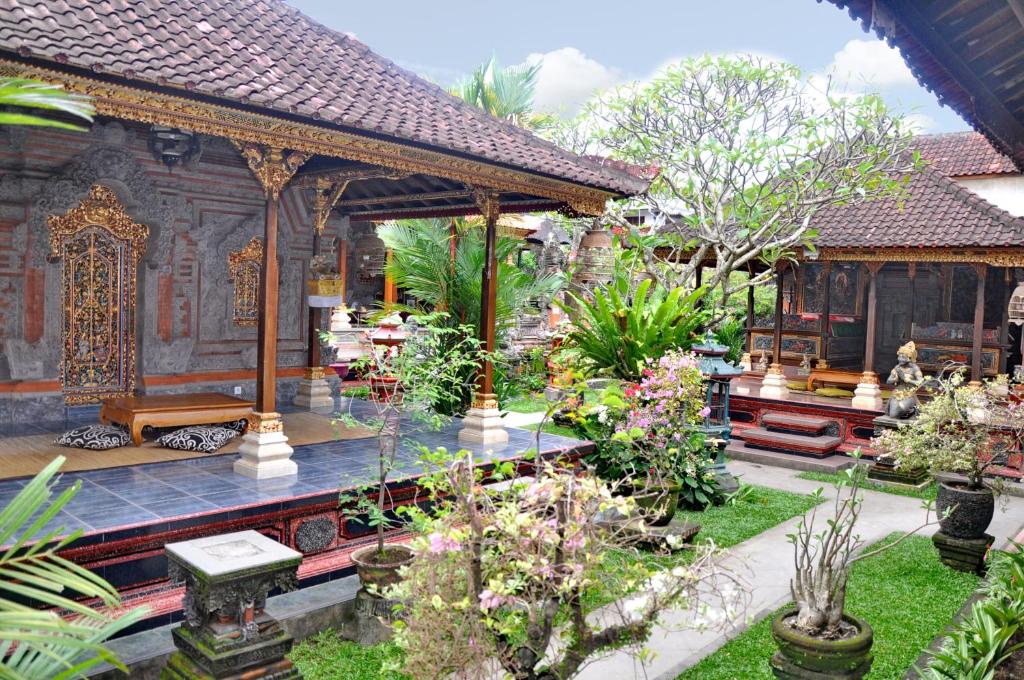 a garden in front of a house with plants at Nick's Homestay in Ubud