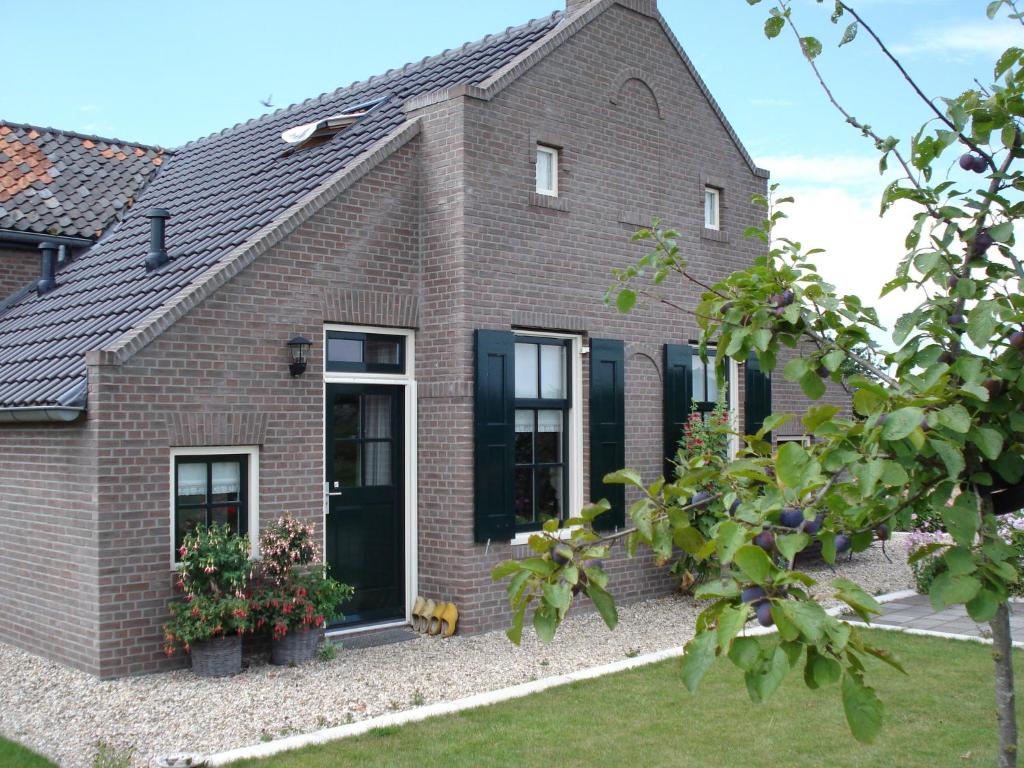 a brick house with black doors and windows at 't Kruushuus in Welsum