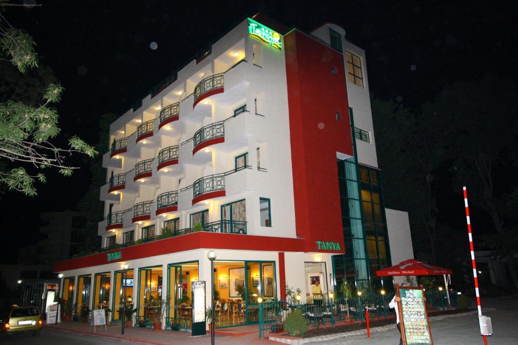un grande edificio rosso e bianco con un cartello sopra di Tanya Hotel a Sunny Beach