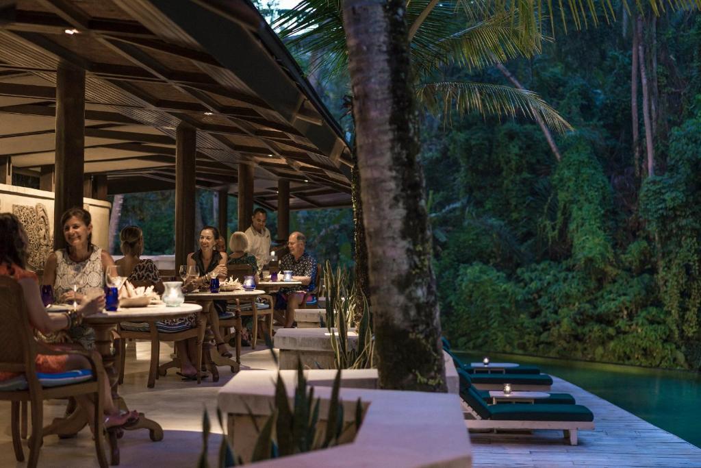 a group of people sitting at tables in a restaurant at Four Seasons Resort Bali at Sayan in Ubud