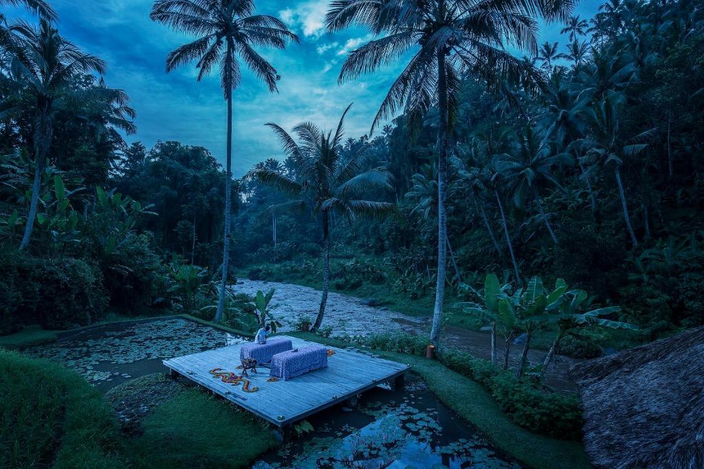 a blue chair sitting on a raft in a river with palm trees at Four Seasons Resort Bali at Sayan in Ubud