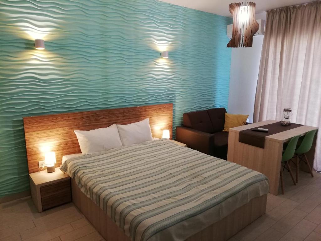 ママイアにあるDelos Studio With Sea Viewのベッド1台、デスク、ベッドサイドシックスシックスシックスが備わる客室です。