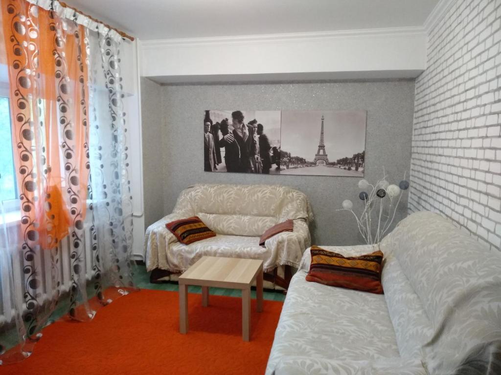 a room with two beds and a couch and a table at Apartments on Samal 1 in Almaty