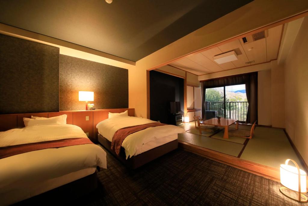 Postel nebo postele na pokoji v ubytování Hotel Kamogawaso