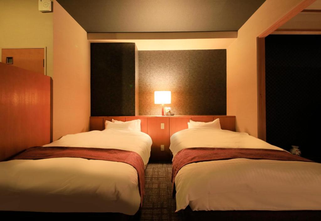 Postel nebo postele na pokoji v ubytování Hotel Kamogawaso