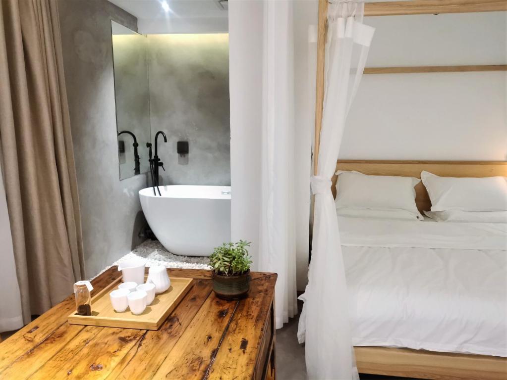 a bedroom with a tub and a bed and a table at Moonlight Hotel in Chengdu