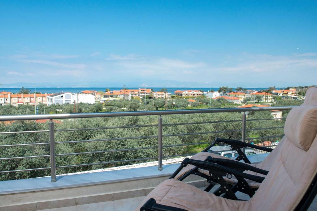 a balcony with a chair and a view of a city at Maria's Sea View Villa in Skala Rachoniou