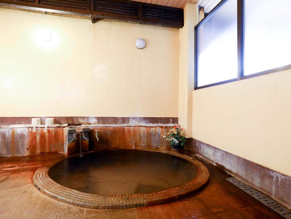a large pool of water in a room with a window at Ikariya Ryokan in Yamanouchi
