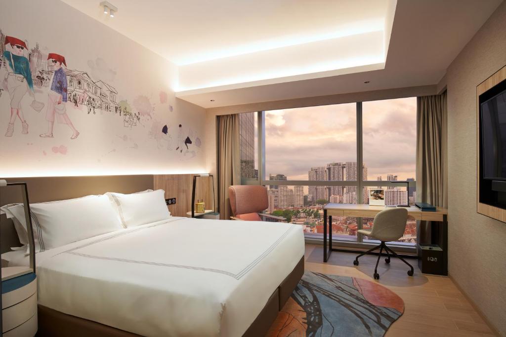 a hotel room with a bed and a desk at Capri by Fraser China Square, Singapore in Singapore
