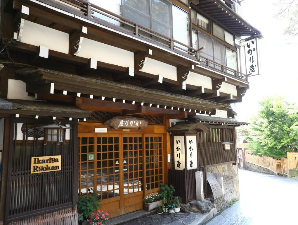 a building with a sign on the side of it at Ikariya Ryokan in Yamanouchi