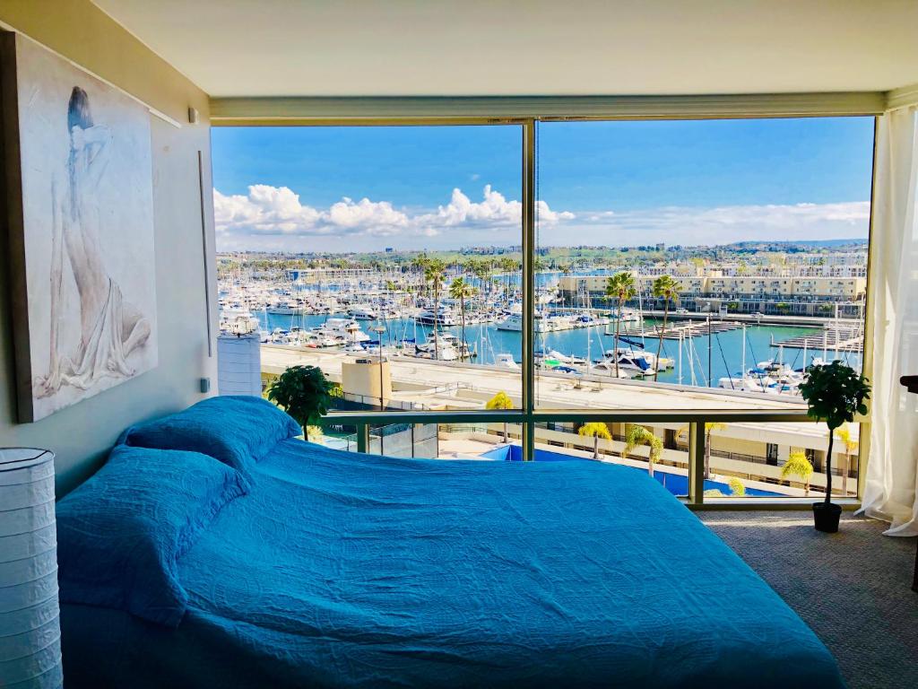 a bedroom with a blue bed and a large window at Fantastic Marina View in Front of My Window! in Los Angeles
