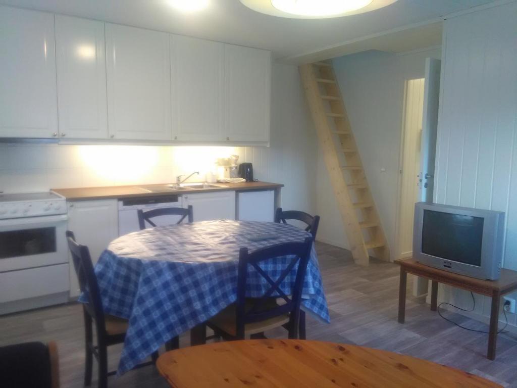 a kitchen with a table and a tv in a room at Bjørgo Gard - Stegastein in Aurland