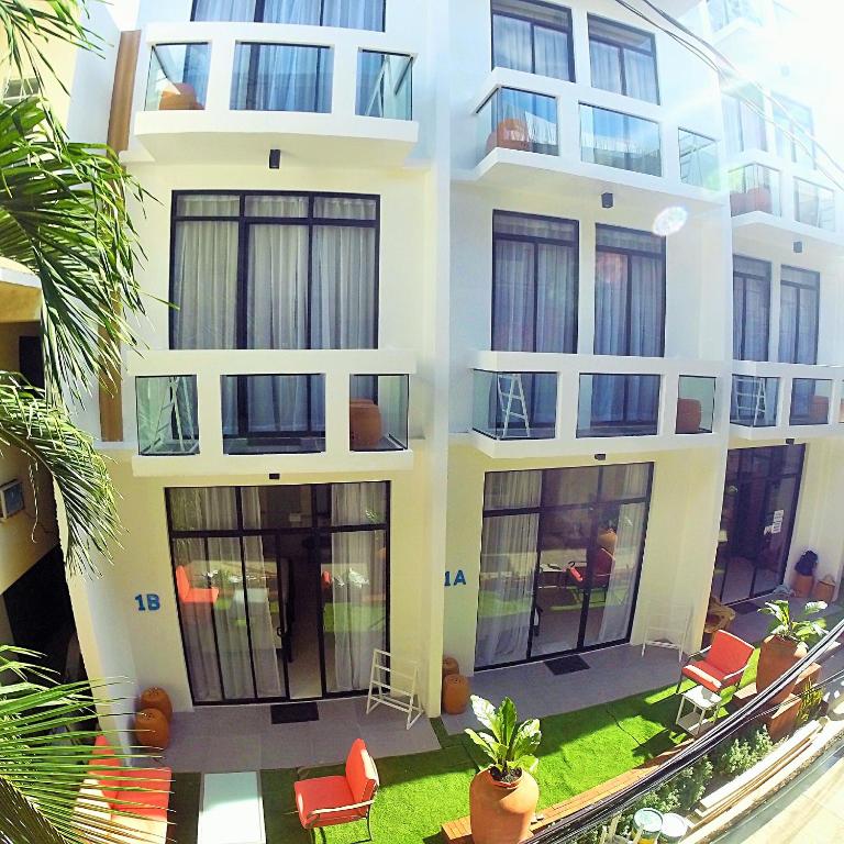 a building with windows and chairs in a yard at Luxx Boutique Boracay in Boracay