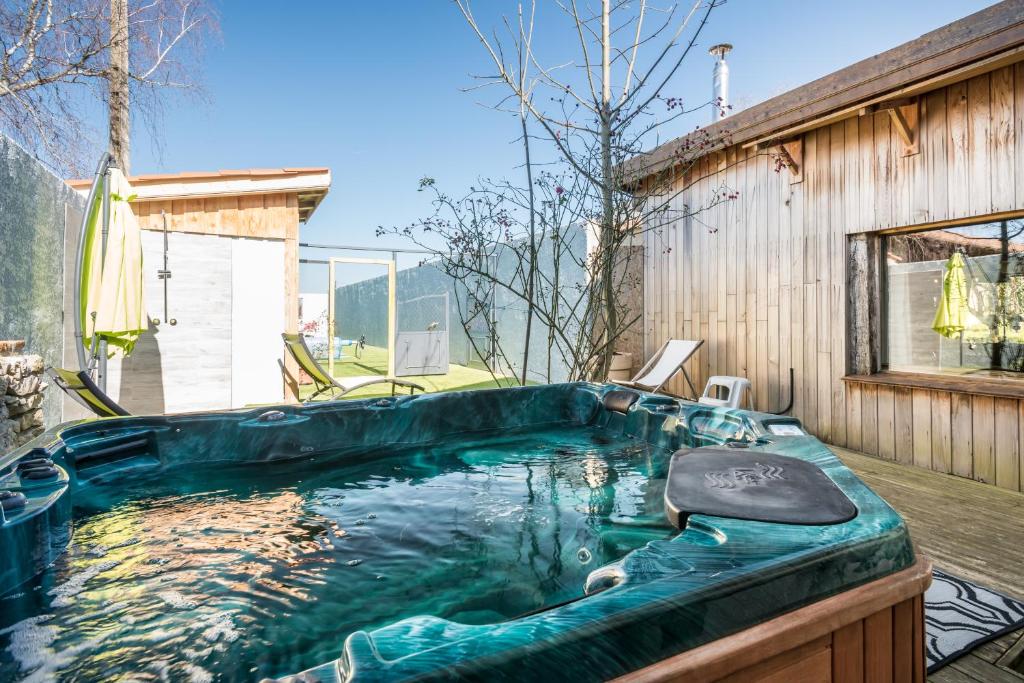 a hot tub in the backyard of a house at Haras Picard Du Sant Le Chalet in Lasserre