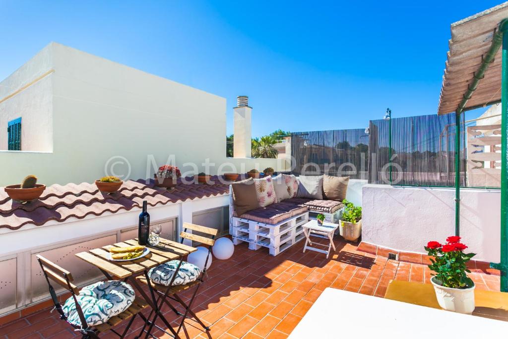a patio with a couch and chairs on a roof at Orellana in Can Picafort