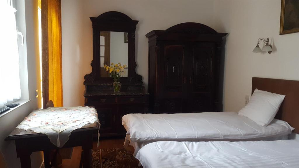 a bedroom with two beds and a dresser and a mirror at Room in An Old House in Truskavets