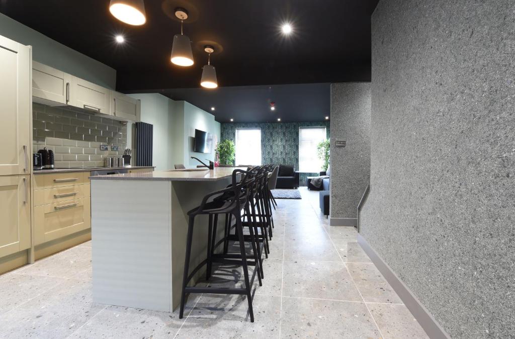 a kitchen with a bar with stools in it at La Jungle Du Swan in Manchester