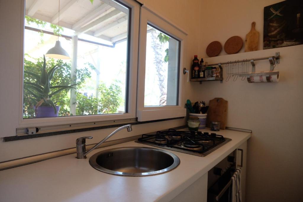 a kitchen with a sink and a stove and a window at Villa Cavallaro in Acitrezza