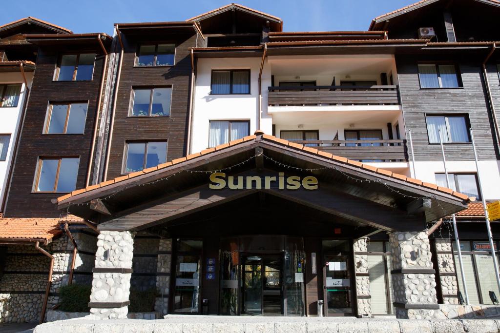 班斯科的住宿－Bansko Holiday Apartments，上面有太阳升起标志的建筑