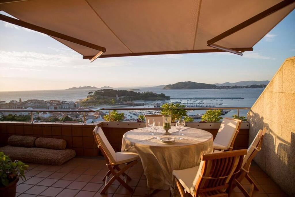 a table on a balcony with a view of the ocean at Inmejorables vistas a las islas Cies in Baiona