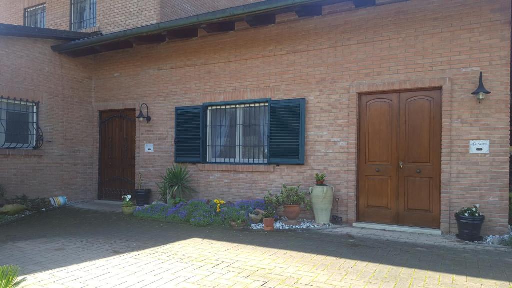 une maison en briques avec une porte en bois et des fleurs dans l'établissement Casa Monaco, à Auletta