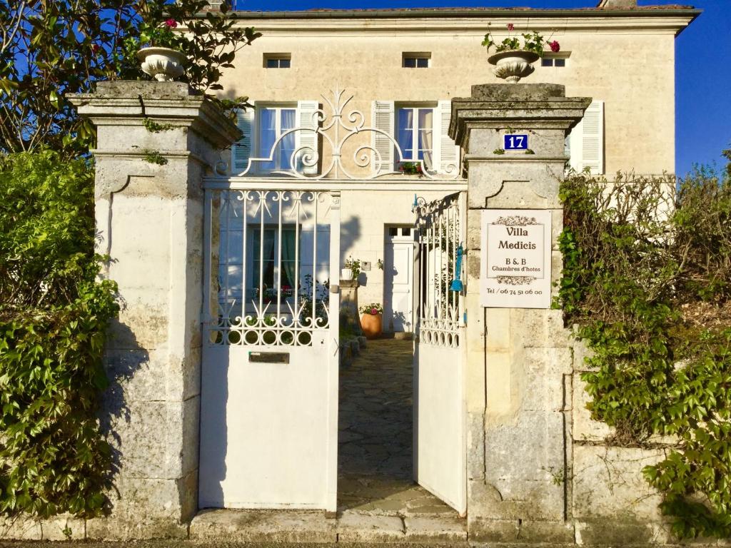 un accès à un bâtiment blanc avec une porte dans l'établissement Villa Medicis, à Brantôme
