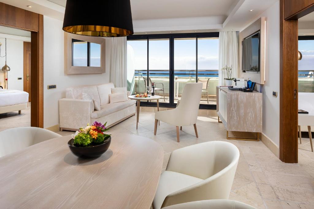 a living room with a table and chairs with a view of the ocean at Hotel Don Pepe Gran Meliá in Marbella