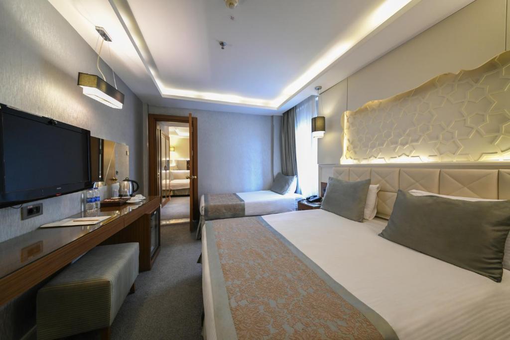 イスタンブールにあるStyle Star Hotel Cihangirのベッド1台、薄型テレビが備わるホテルルームです。