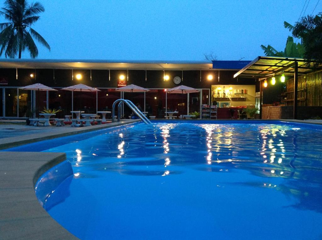 a swimming pool in front of a building at night at Nest Boutique Resort in Lat Krabang