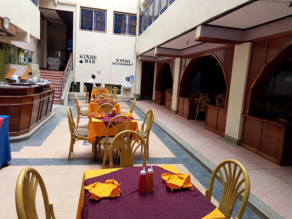 a restaurant with tables and chairs and a building at Nanyuki Ibis Hotel in Nanyuki