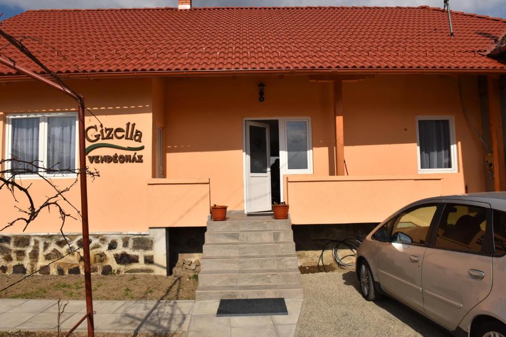 una casa con un coche aparcado delante de ella en Gizella vendégház, en Odorheiu Secuiesc