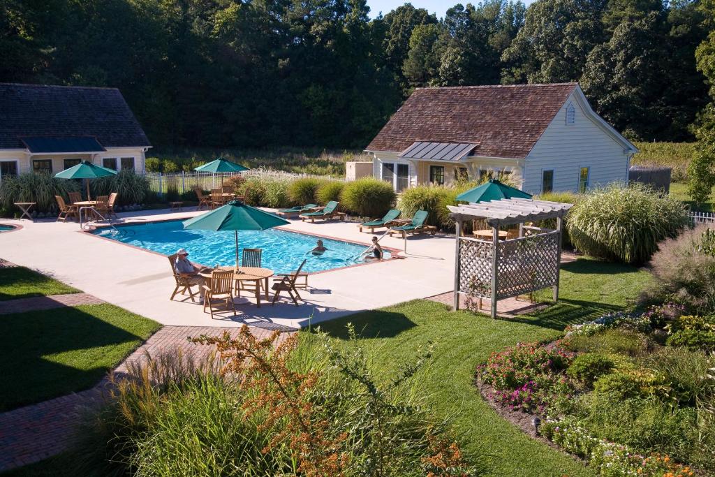 an overhead view of a swimming pool with tables and umbrellas at George Brooks House B&B in Saint Michaels