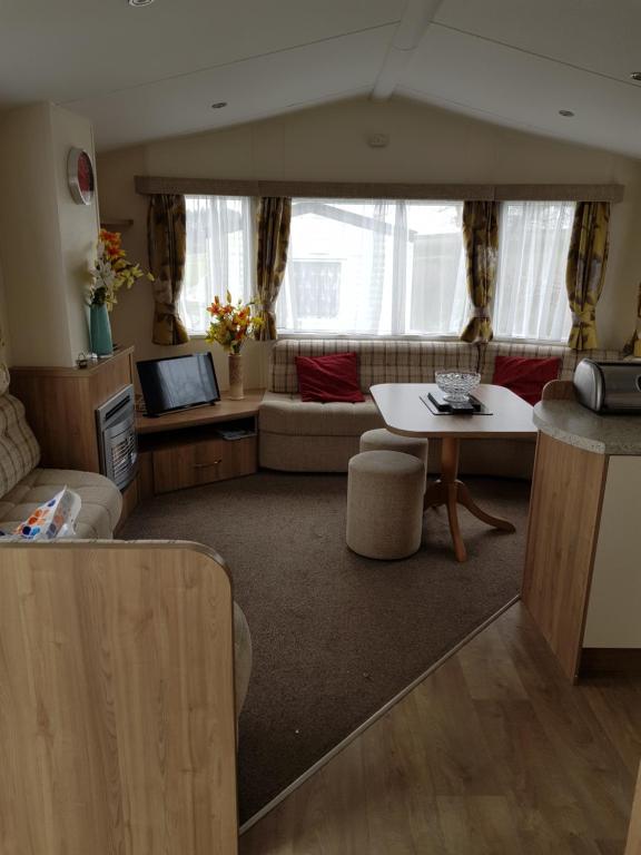 a living room with a couch and a table at Caravan Willerby Rio in Looe