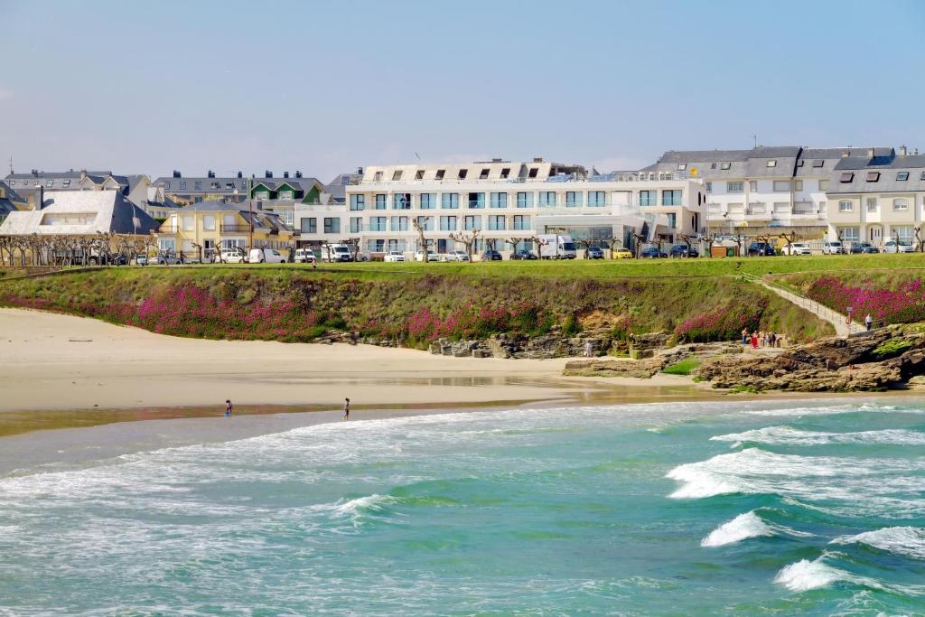 a view of a beach with buildings in the background at Oca Playa de Foz Hotel&Spa in Foz