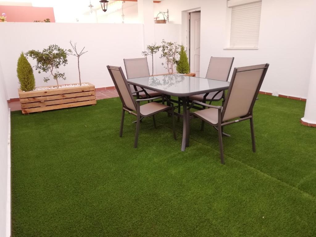コニル・デ・ラ・フロンテーラにあるApartamento Villamartínの緑の芝生の上にテーブルと椅子