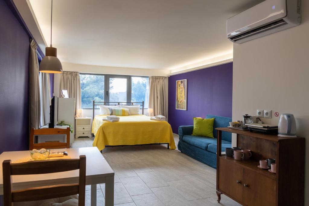 sala de estar con cama y habitación con sofá en CHROMA Lodge Pikermi, en Pikérmion