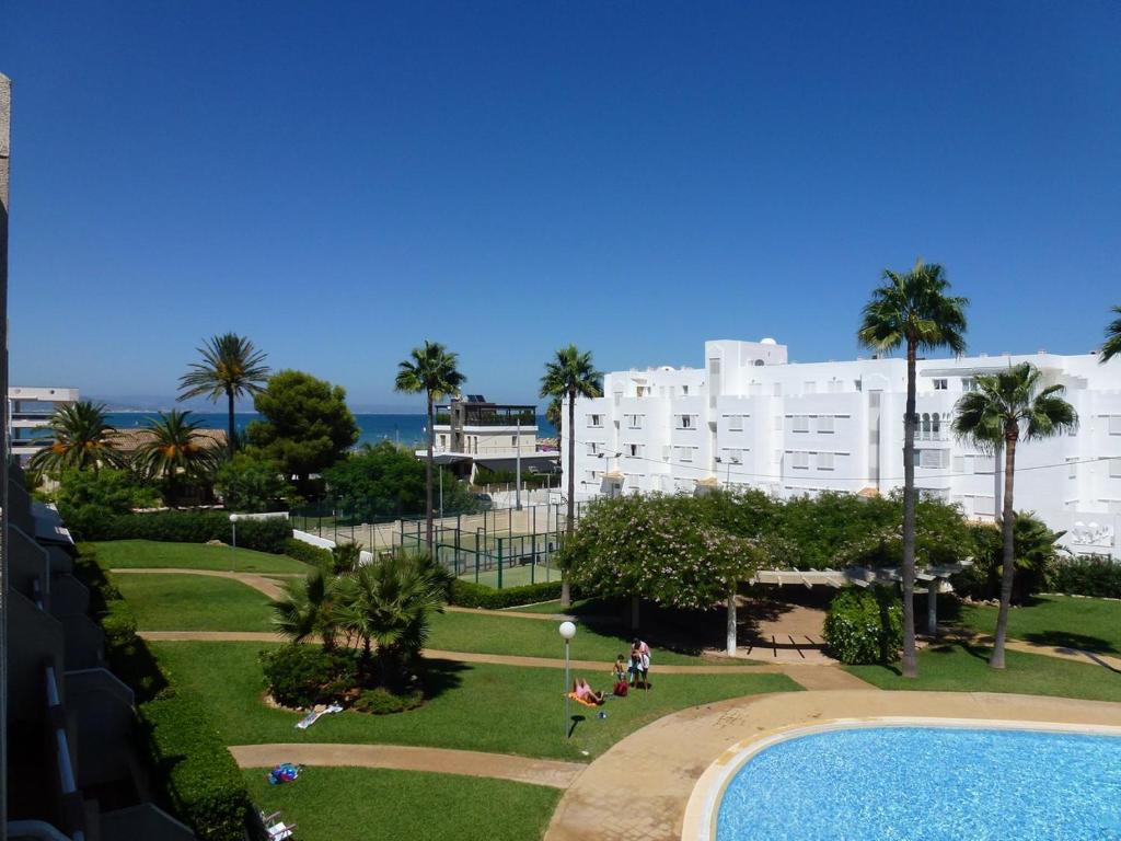 Blick auf einen Park mit Pool und Gebäuden in der Unterkunft Ático Duplex en 1a línea de mar in Denia