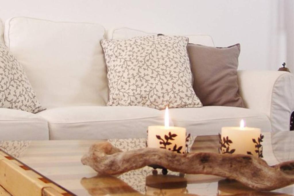 soggiorno con divano e candele sul tavolino di artística a Ermioni