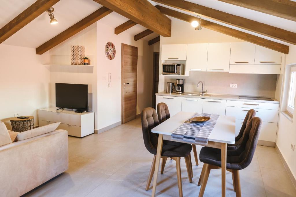 a kitchen and living room with a table and chairs at Fonda Apartments in Koper