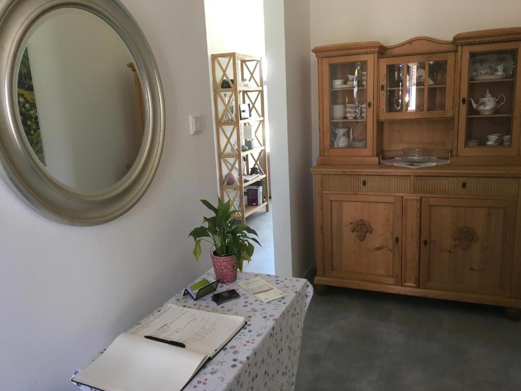 a room with a table with a mirror and a cabinet at Klause am grünen Hof in Friesoythe