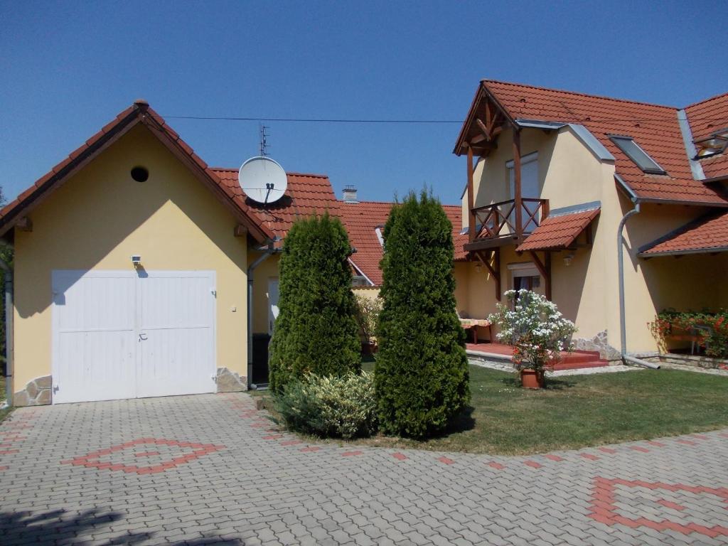 una casa con un garaje blanco y dos árboles en Anna villa, en Lenti