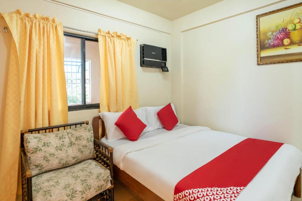 a bedroom with a bed and a chair and a window at Conrado's Apartelle in Manila