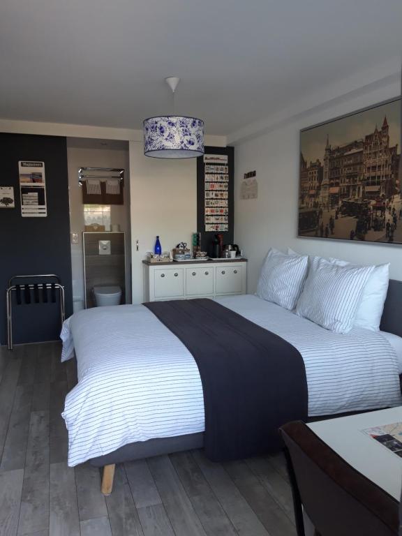 sypialnia z dużym białym łóżkiem i stołem w obiekcie JamieK's BnB w Amsterdamie